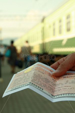 Два билета на поезд в руке