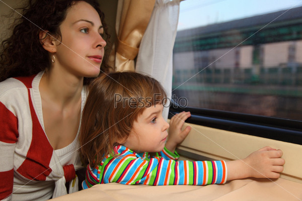 mother and daughter look in train`s window