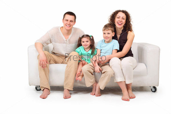 Family with two children sitting on white leather sofa