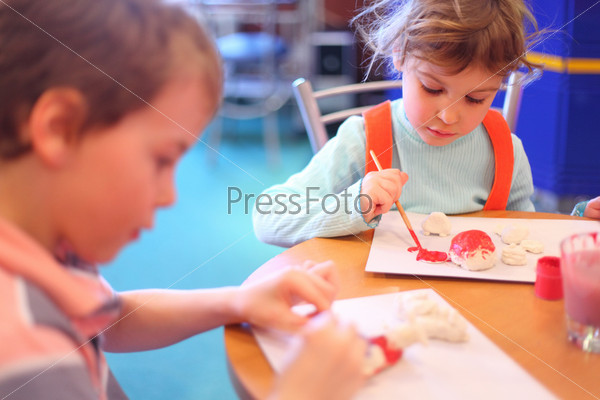 Children paint toys from clay