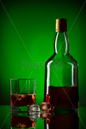 Whiskey bottle, ice and glass