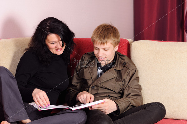 The teenager with parents considers the book, stock photo