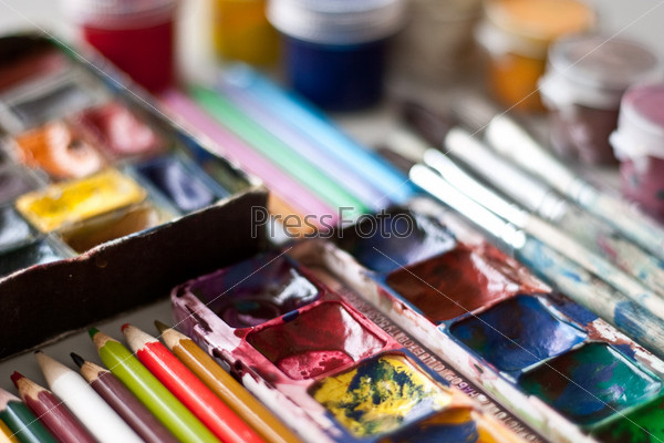 Items for drawing and art: watercolor paint, brushes, colored pencils, stock photo