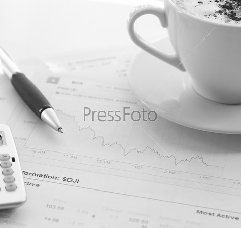 Business still-life: the stock reports, pen, calculator and a mug of coffee