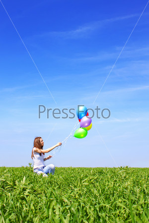 Girl in a field with balloons