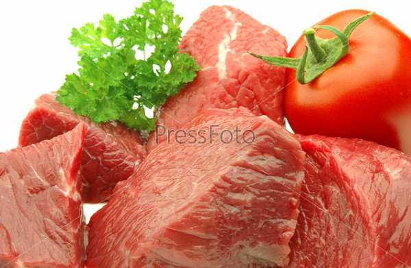 Fresh pieces of meat closeup with vegetables and greens