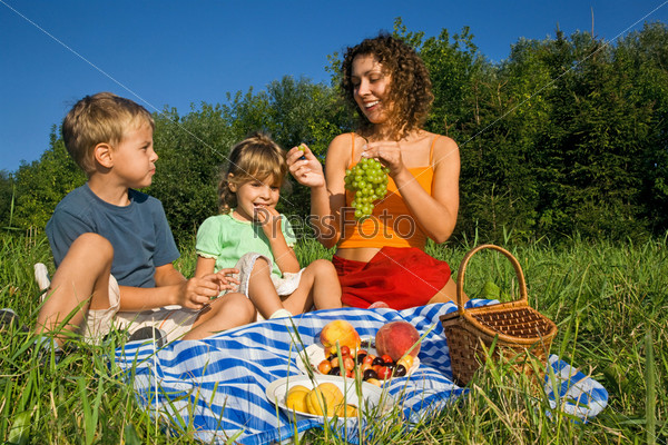 pretty Little Girl and Young Women and Little Boy on picnic in garden
