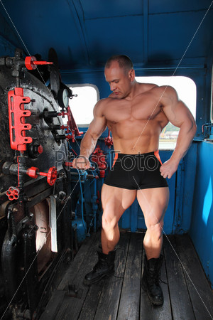 athlete in locomotive cabin full body with open furnace