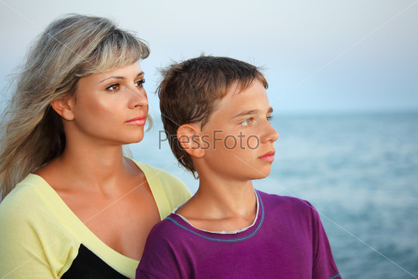 boy and young woman on beach in evening, Looking afar