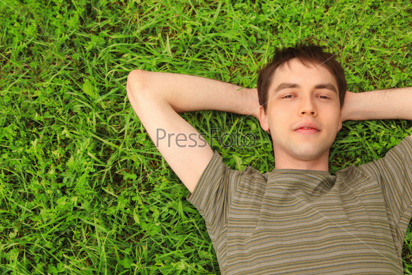young man lies on grass