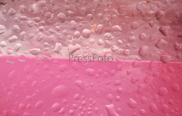 Капли воды на розовом стекле