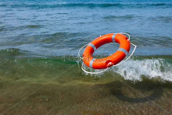 Red lifebuoy flying in the sea wave