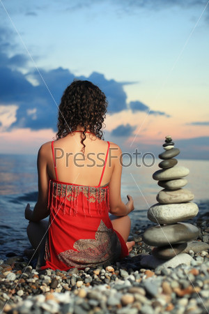 Девушка медитирует на пляже