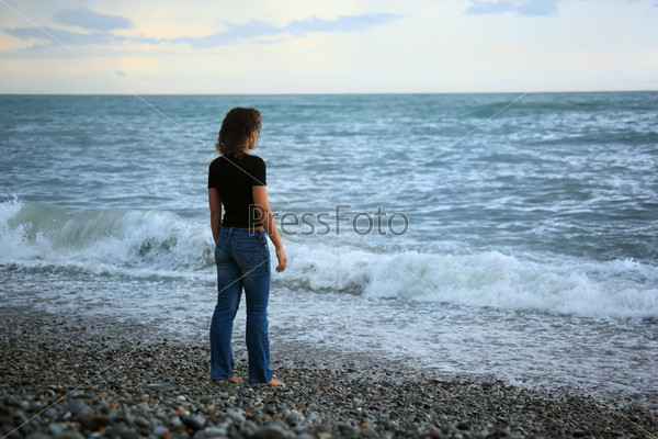 beautiful woman on stone stone seacoast, Standing back