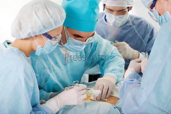 Portrait of four medical professionals performing an operation on woman