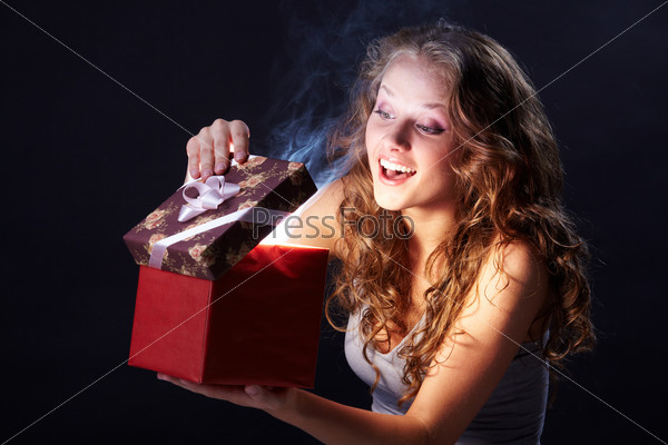 Image of pretty woman looking into gift box and wondering