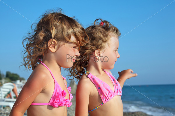 two pretty little girls on beach near sea, Looking afar