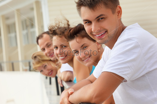 Five smiling friends on balcony