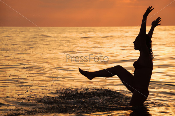 Silhouette beautiful woman play in sea in evening