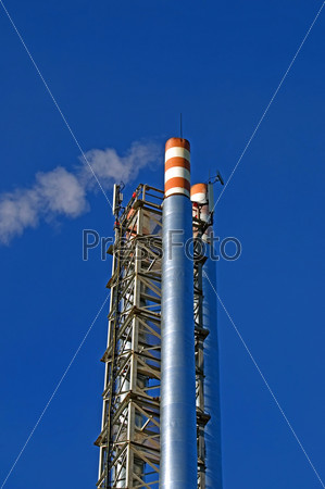 Pipes, gas boiler house with a withdrawing smoke against the blue sky