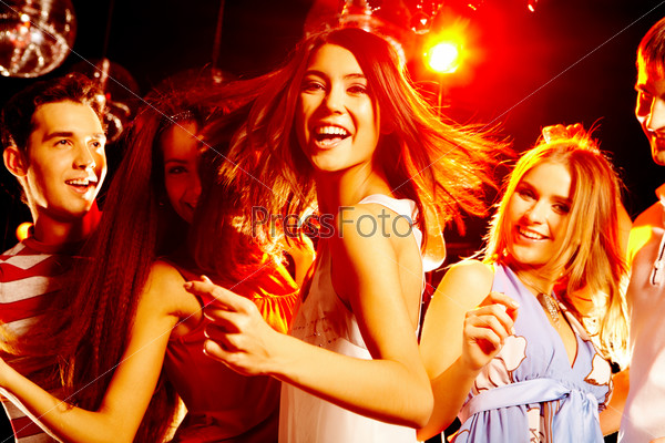 Portrait of laughing girl in white dress dancing among her friends, stock photo
