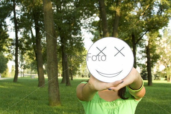 Young woman outdoors in the hands of the face of the picture with a smile