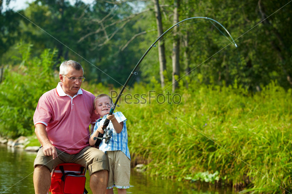 Photo of grandfather and grandson fishing on weekend