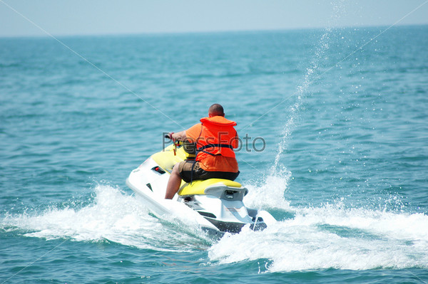 Man driving a motorised scooter at sea - more similar photos in my portfolio