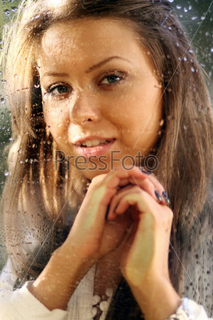Young woman near the window after the rain