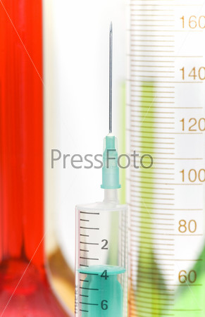 Close up of medical syringe and lab glassware