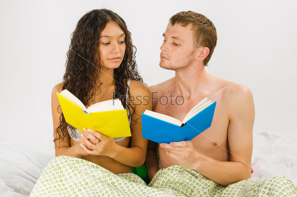 Just married couple resting at the bedroom with books