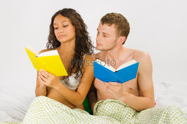 Just married couple reading books at the bedroom