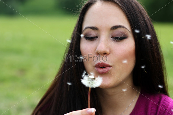 young girl with a dandelion in hands