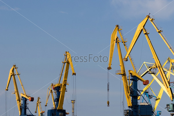 Cranes working at commercial dock with clear blue sky at the background