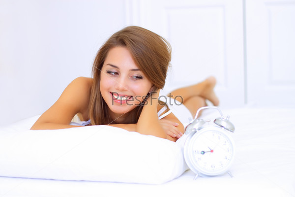 smiling young woman looks at the clock