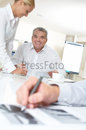 Portrait of happy boss looking at one of workers during office work