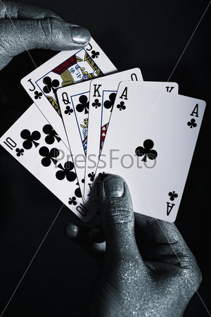 Metal men\'s hands with playing cards on a black background
