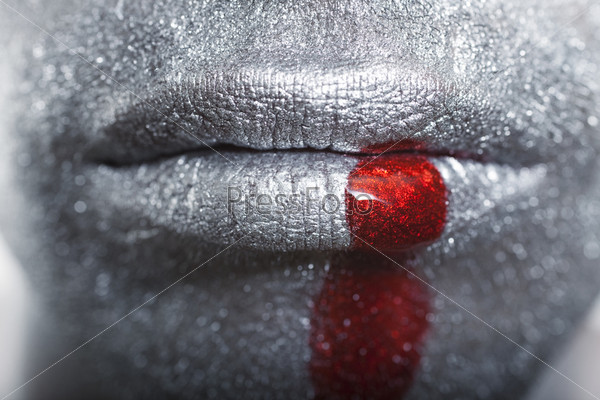 Men\'s lip with a silver makeup and blood closeup