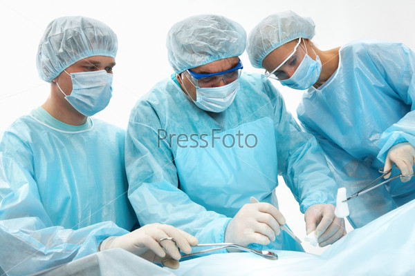 Three surgeons operating on a patient