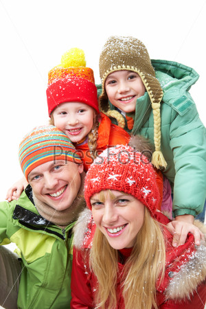 Happy family in winter clothes looking at camera and smiling
