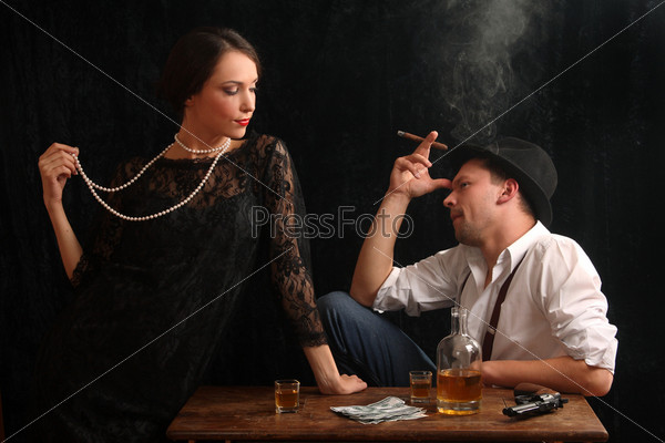 The man-gangster and the beautiful girl talk in a bar