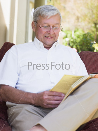 Senior man relaxing with book