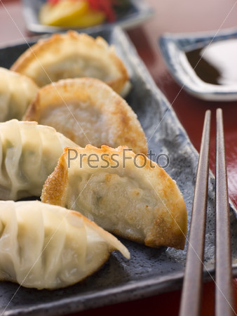 Fried Pork and Shrimp Dumplings on a dish with Soy Sauce and chopsticks