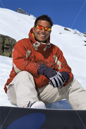 Young man taking a break from snowboarding