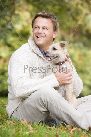 Man sitting outside holding dog