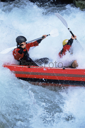 Два молодых человека плывут в лодке по реке
