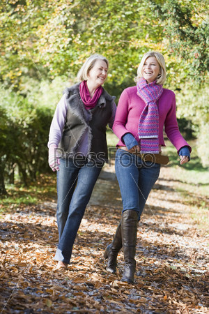 Mother and grown up daughter on walk through woods