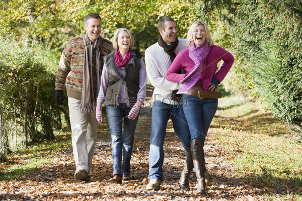 Family group walking through autumn woods