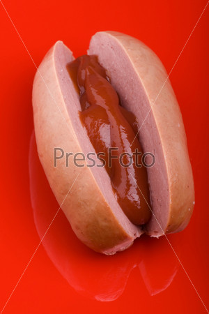 object on red - food sausage with ketchup