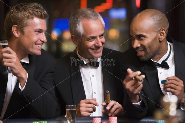 Three men gambling at roulette table in casino